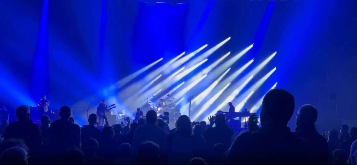 Blue and white stage lights over a concert audience