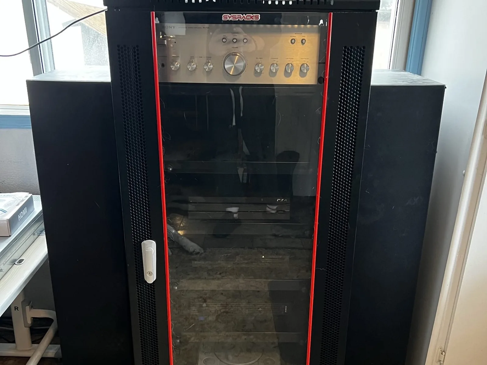 Front view of a tall black console and media rack